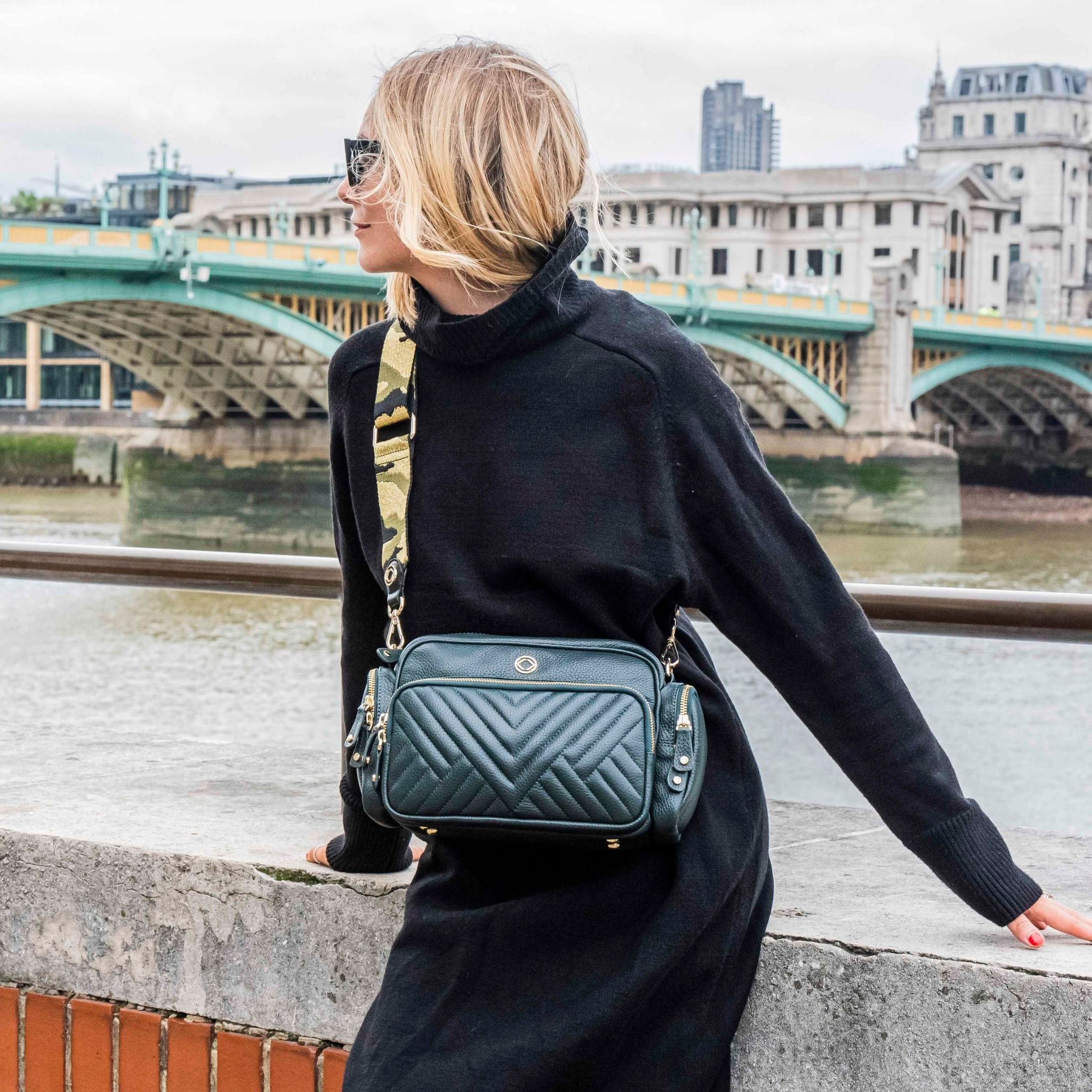 model wearing webster khaki and gold camo leather bag strap across body attached to greta green leather cross body bag