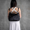 model wearing lennox black leather womens travel bag on back in backpack mode