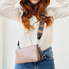 model wearing webster mini muted stripe leather bag strap across body attached to milly mink travel purse